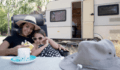 אמא ובתה ליד קראוון למגורים שנקנה באמצעות הלוואה